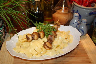 Frische Butterchampignonspieße auf selbstgemachten Bandnudeln