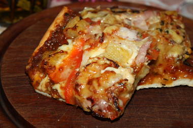 Pizza mit Schinken, Zwiebeln, Tomaten,und Käse