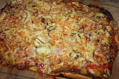Pizza mit Schinken, Zwiebeln, Artischockenherzen und Käse